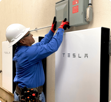 construction worker installing a Tesla battery