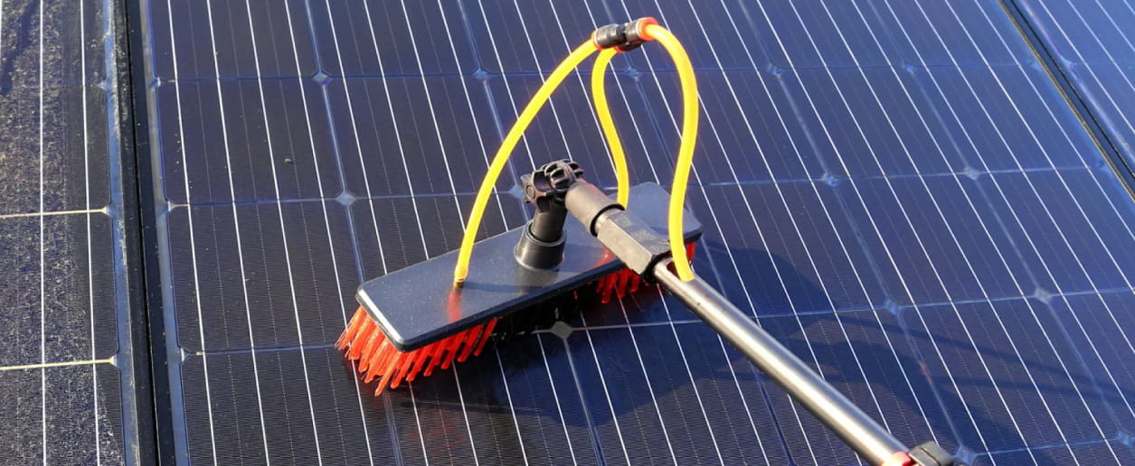 A solar panel cleaner on a rooftop scrubbing a solar panel